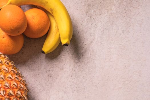 Tropical and Seasonal Summer Fruits. Pineapple Oranges and Bananas Arranged in corner of backgrounds, Healthy Lifestyle. Flat Lay