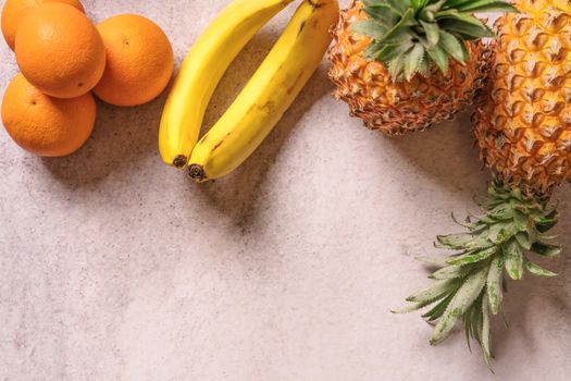 Tropical and Seasonal Summer Fruits. Pineapple Oranges and Bananas Arranged in upper of backgrounds, Healthy Lifestyle. Flat Lay