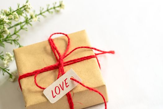 Gift box and flower, paper tag LOVE texting and copy space