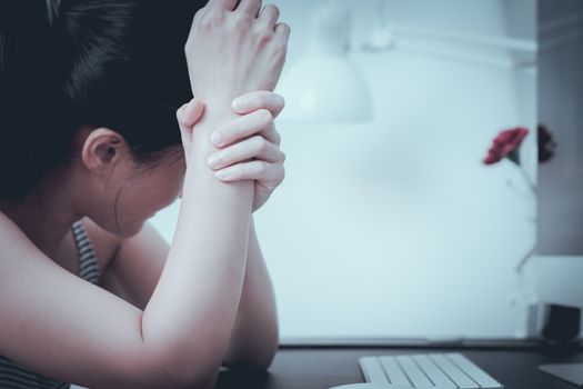 depressed women sitting in front computer after hard working alone sadness emotional and wrist arm pain. office syndrome healthcare and medicine concept