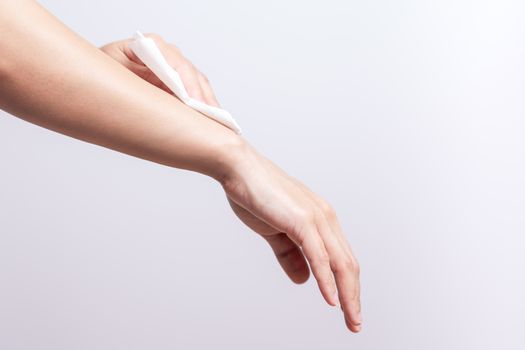 Woman cleaning her arm with white soft tissue paper. isolated on a white backgrounds