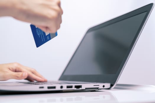 Hands holding credit card and using laptop. Online shopping