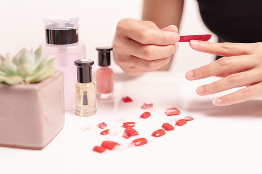 women manicure and attaches a nail shape during the procedure of nail extensions with gel at home. Fashion and Beauty concept