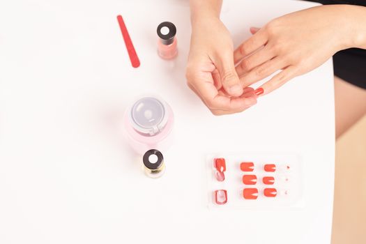 women manicure and attaches a nail shape during the procedure of nail extensions with gel at home. Fashion and Beauty concept