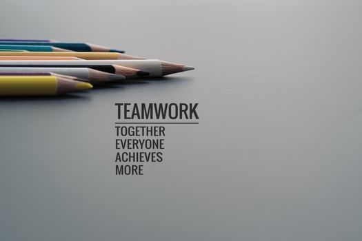 Teamwork concept. group of color pencil on black background with word Teamwork, Together, Everyone, Achieves and More