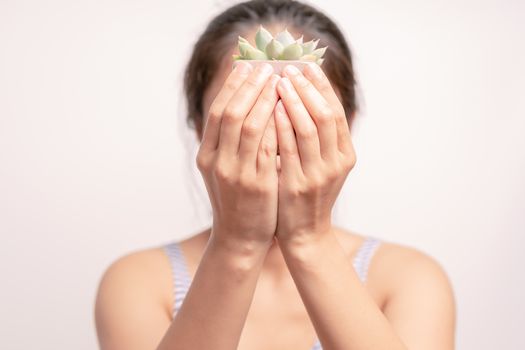 Women holding a green cactus tree on white background