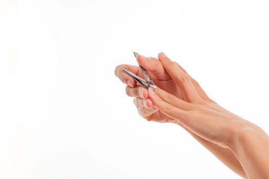 woman hand cutting nails using nail clipper on white backgrounds