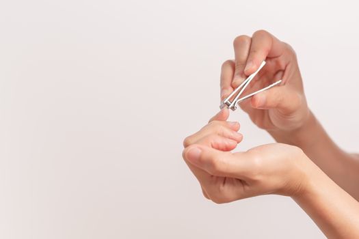 woman hand cutting nails using nail clipper on white backgrounds