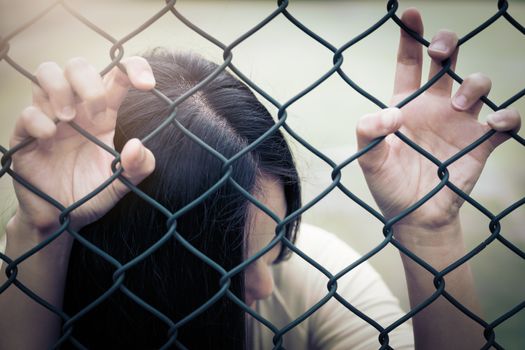 Depressed, trouble and solution. Hopeless women hand on chain-link fence.