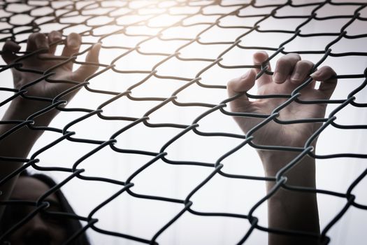 Depressed, trouble and solution. Hopeless women hand on chain-link fence.