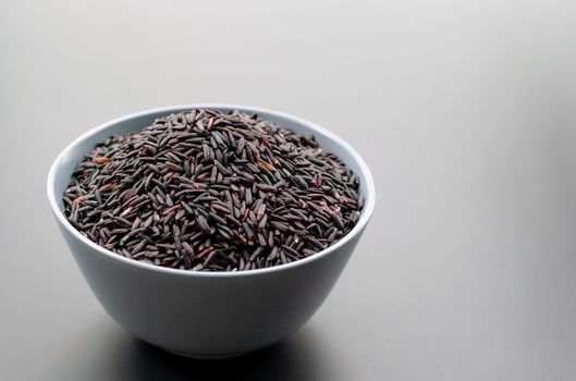 bowl of jasmine black rice on black backgrounds