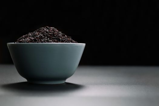 bowl of jasmine black rice on black backgrounds