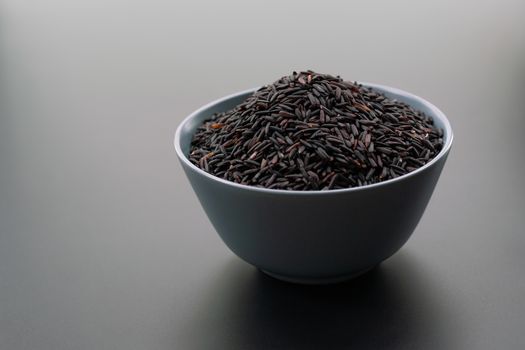 bowl of jasmine black rice on black backgrounds