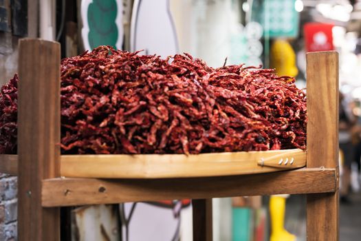 Dried chillies in the threshing basket on wooden case, selective focus