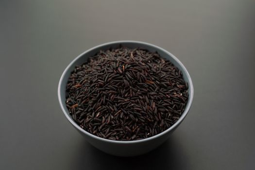 bowl of jasmine black rice on black backgrounds