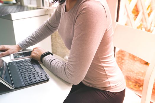 Young student women wearing smart band focus on her tablet computer and smart phone