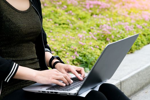 A student woman is typing on laptop computer