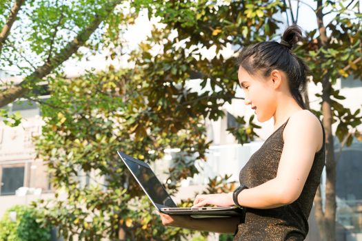 A woman is holding laptop computer to surfing internet