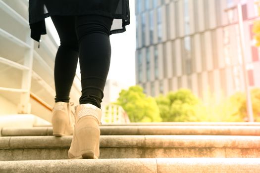 A business women is stepping on stair for successful