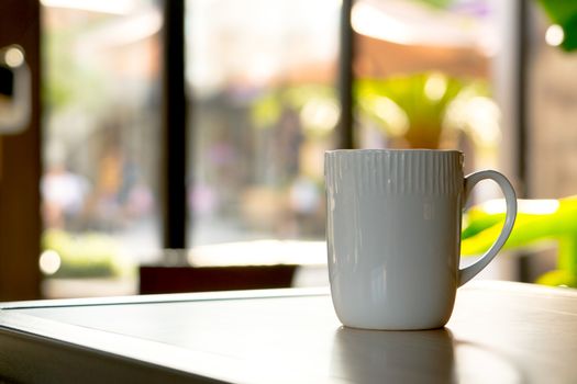 A mocha or cappuccino hot coffee in white cup on the wooden table