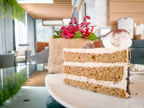 A mocha cake with red orchid on the cozy coffee table