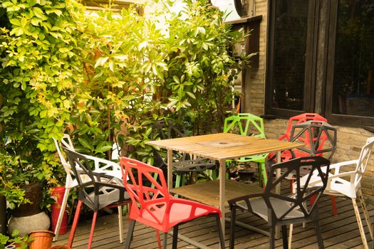 A corner of outdoors table and colorful chairs