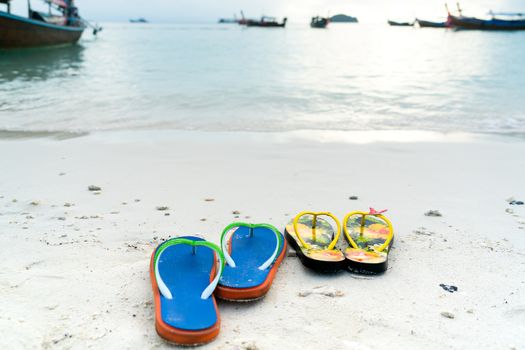 2 slippers on the white sand beach, travel and vacation time