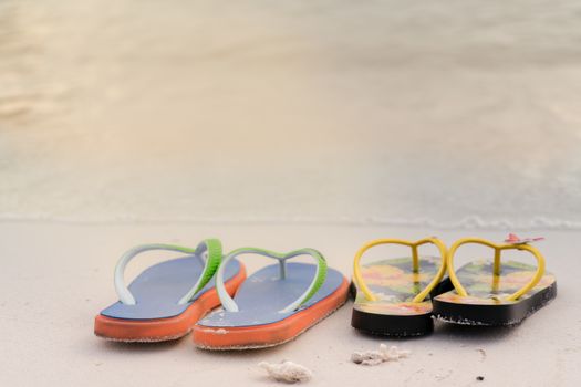 2 slippers on the white sand beach, travel and vacation time