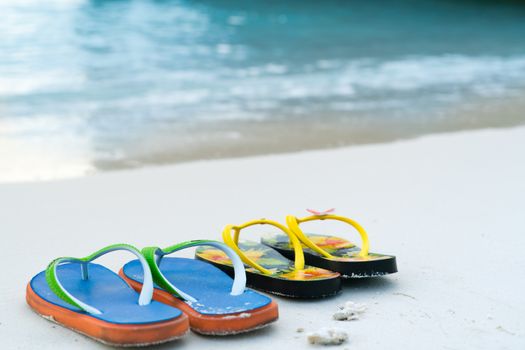 2 slippers on the white sand beach, travel and vacation time