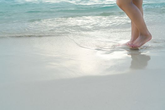 Beach travel - girl walking on the white sand beach, vacation and relax