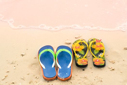 2 slippers on the white sand beach, travel and vacation time