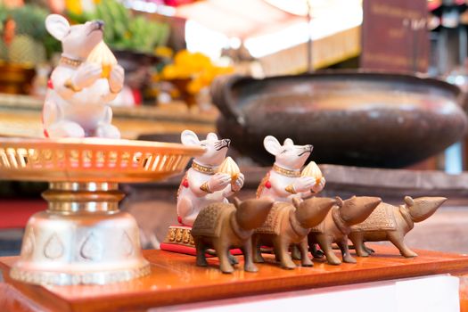 the statue of the small white and brown rat on the table in the shrine temple