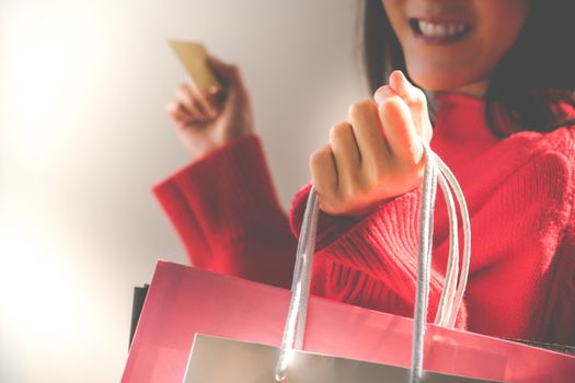 Happy girl holding the colorful shopping bag and credit card for family new year gift - applied matt soft focus filter