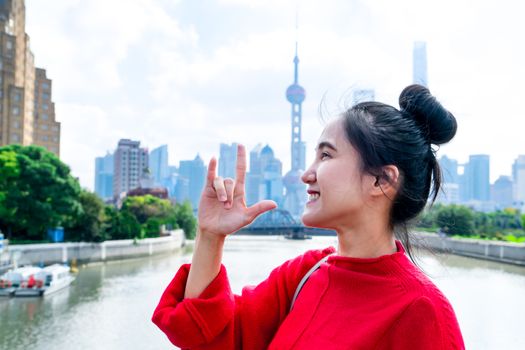 the smile woman body language of love sign with the urban Shanghai landmark city