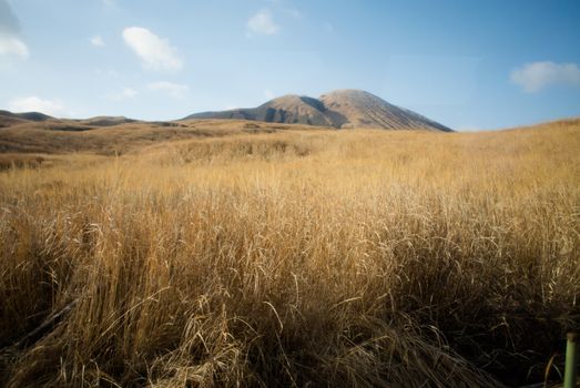 Mount Aso and Kusasenri in winter. covered by golden yellow grassland - Kumamoto, Japan