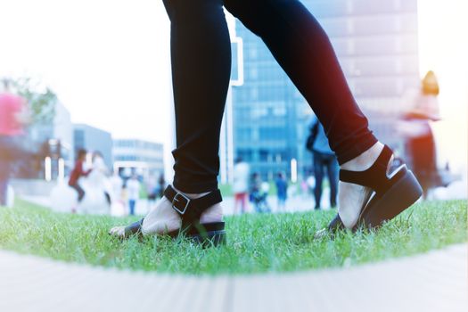 Women step forward to success, young women is stepping forward on green grass near business building