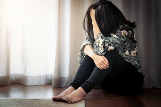 depressed women sitting near curtain in living room, alone, sadness, emotional concept