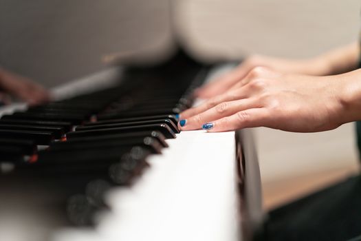women hand on classic Piano keyboard closeup