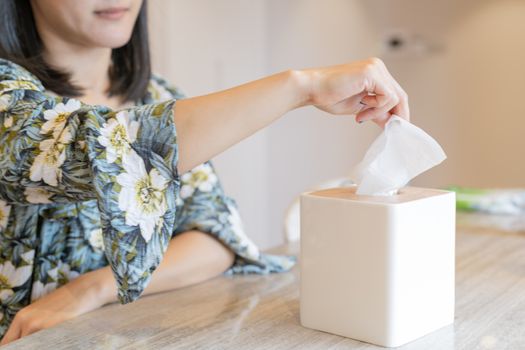 women hand picking napkin/tissue paper from the tissue box