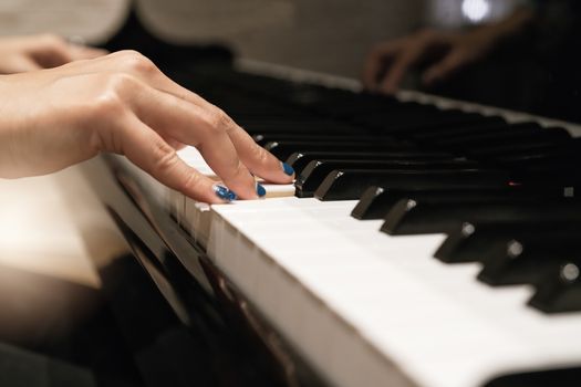 women hand on classic Piano keyboard closeup