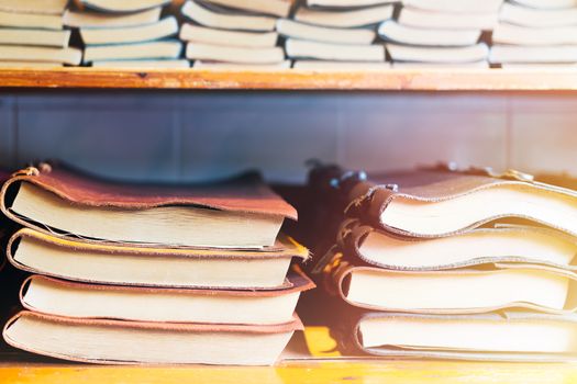 book stack on wooden shelf, colorful leather cover book