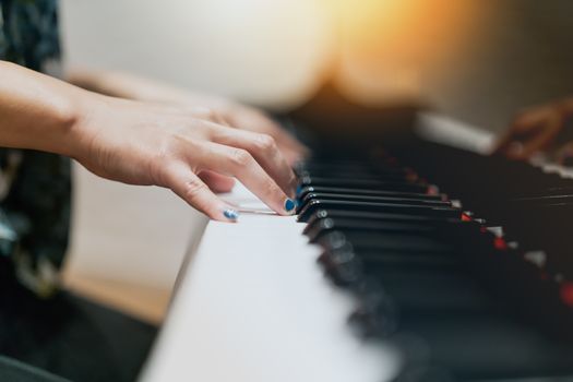 women hand on classic Piano keyboard closeup