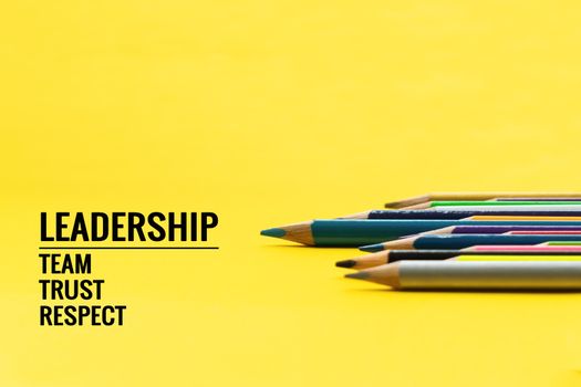 Leadership business concept. Blue color pencil lead other color with word Leadership, team, trust and respect on yellow background