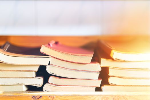 book stack on wooden shelf, colorful leather cover book