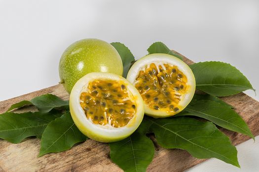 A group of  passion fruit in a wood, two halves of a maracuya fruit, with the dough and the seeds in sight