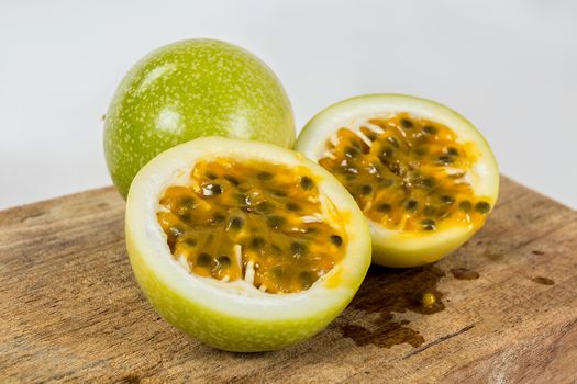 A group of  passion fruit in a wood, two halves of a maracuya fruit, with the dough and the seeds in sight