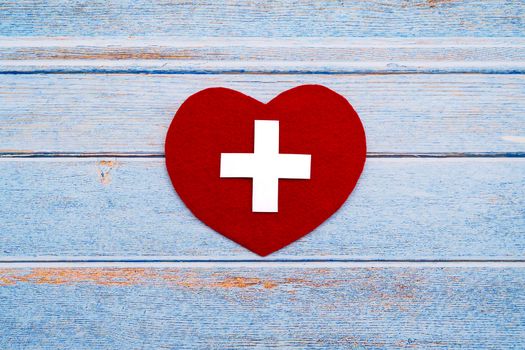 World Red Cross day. Red heart on wooden table background