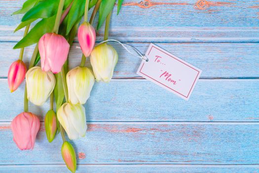 Happy mother's day concept. flower and paper tag on wooden table