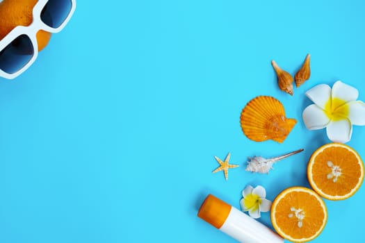 Beautiful summer holiday, Beach accessories, orange, shells and sunblock on blue backgrounds