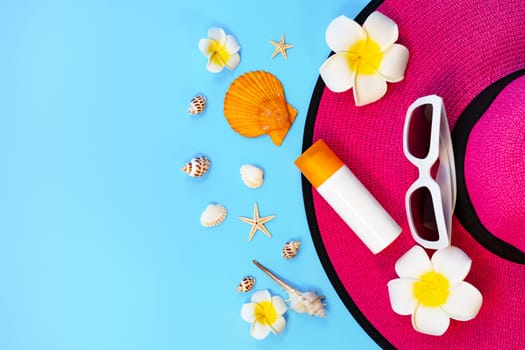 Beautiful summer holiday, Beach accessories, sunglasses, hat, sunblock and shells on blue backgrounds
